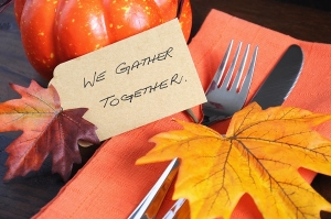 Happy Thanksgiving table place setting with We Gather Together place card and autumn fall leaf decorations