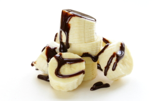 fresh ripe banana with chocolate sauce on white background